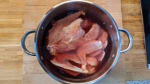 os de porc pied de porc et carcasses de poulet après une nuit au réfrigérateur dans un grand volume d'eau eau rouge de sang